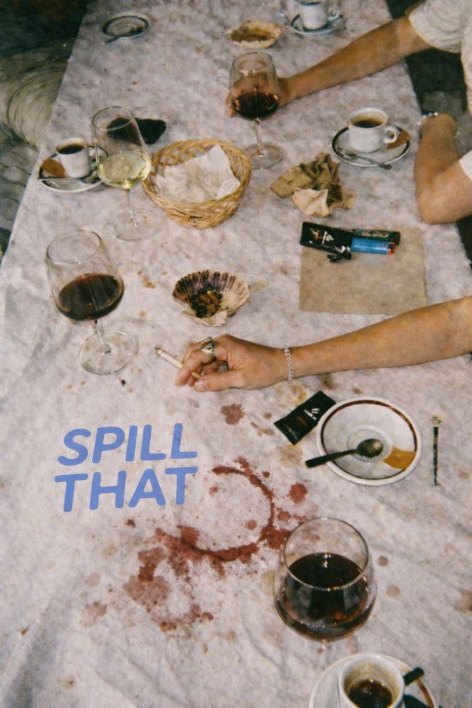 Dinner table with wine stains, glasses, and the Spill That logo